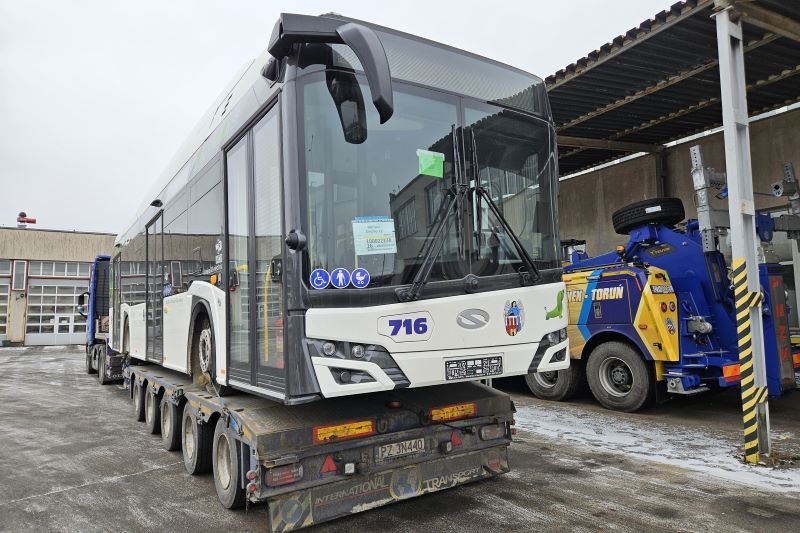 Biały autobus elektryczny w czasie dostawy na lawecie